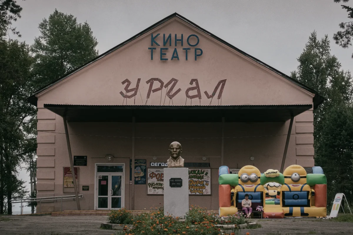 Russian Far East. Chegdomyn, Russia. 2019. Urgal Cinema. In the background, a bust of Lenin; on the right, an inflatable bouncy castle with Pokémon figures. On the poster: Once Upon a Time in Hollywood.