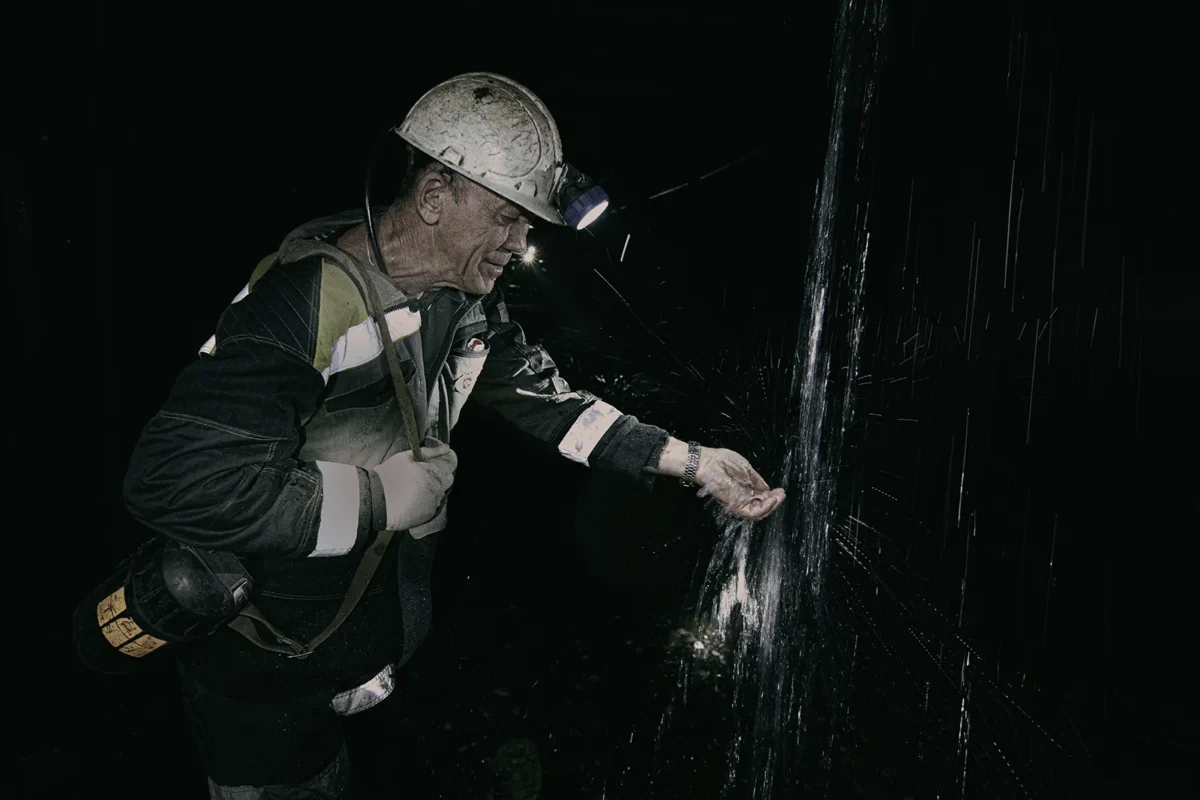 Chegdomyn, Russia. 2019. A miner washes his hands in water breaking through into the coal mine. Having passed through hundreds of meters of coal as a natural filter, it is among the purest on the planet, yet it is dangerous for miners.