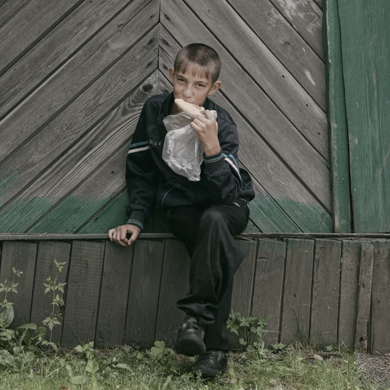 Chegdomyn, Russia. 2022. A child in the settlement eating bread.