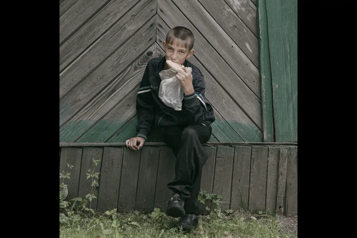 Chegdomyn, Russia. 2022. A child in the settlement eating bread.