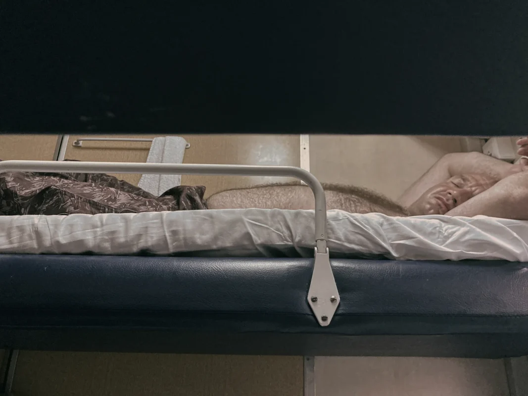 Chegdomyn, Russia. 2022. A rotational worker on the train returning to Khabarovsk after a month-long shift. Such trains often turn into one long vodka bar at the end of a work cycle.