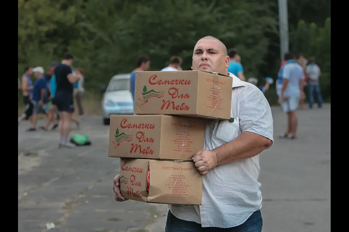A man carries boxes of sunflower seeds to the stadium before the match.